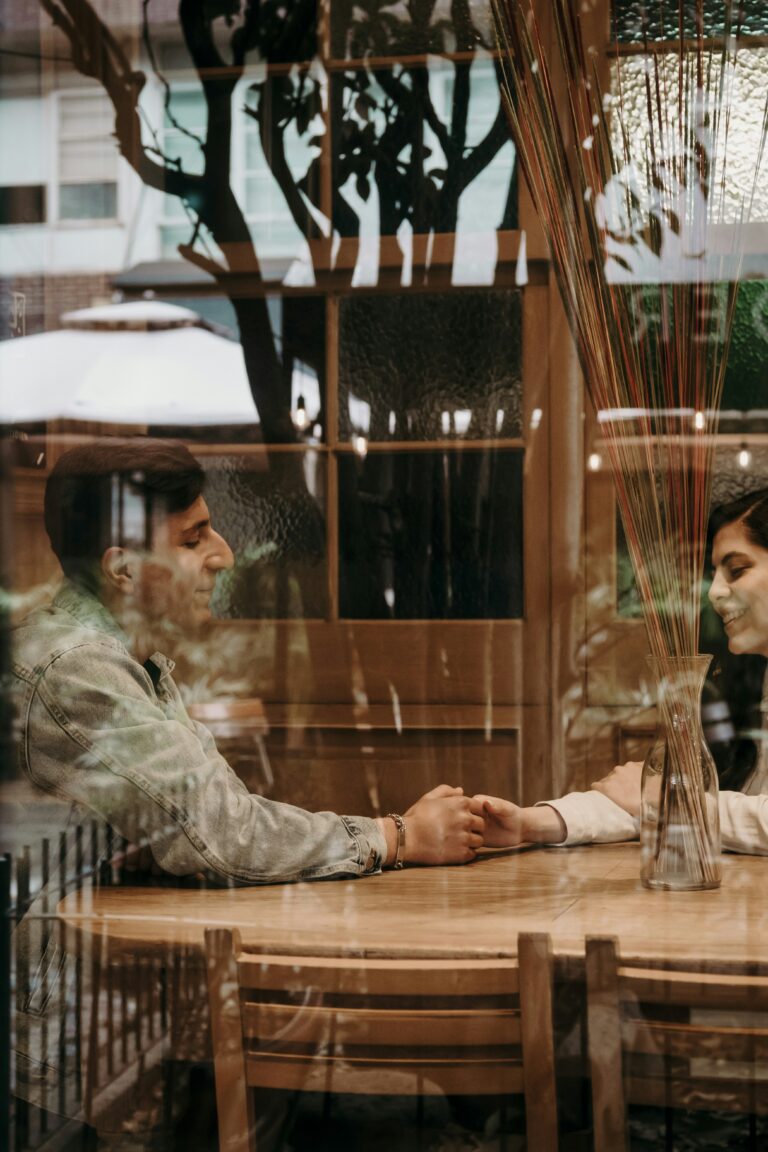 Couple sitting close together looking at a laptop screen in a warm setting