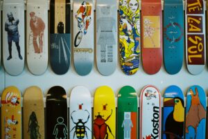 Colorful collection of skateboard decks with various artistic designs displayed on a wall
