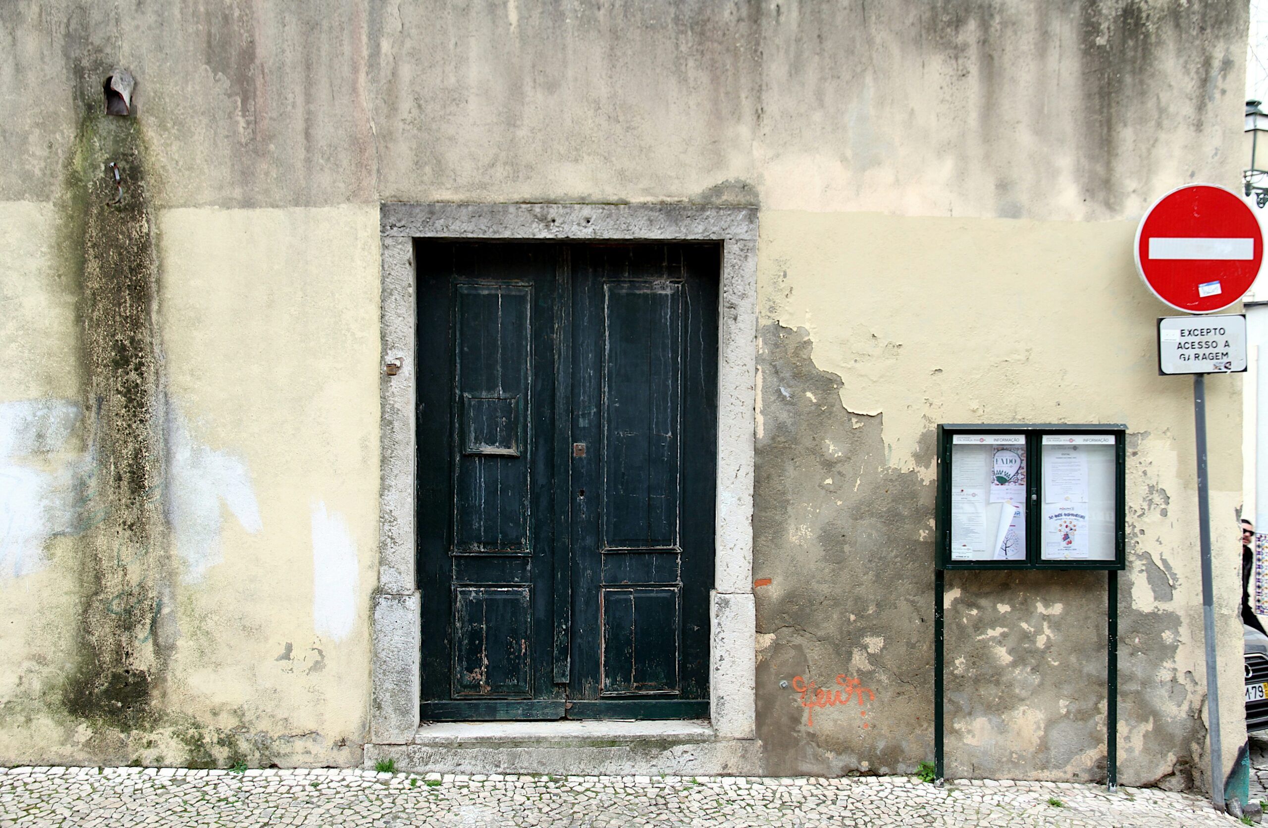 Weathered abandoned building with a red do not enter sign on a crumbling wall