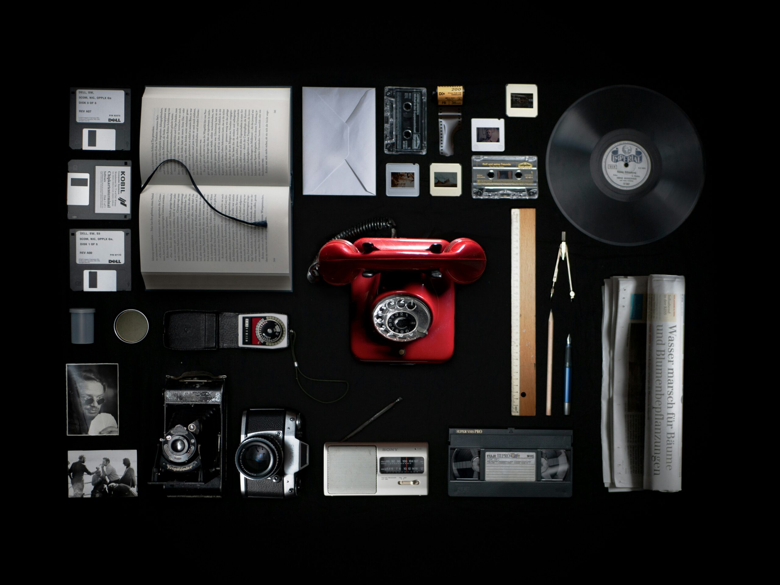 Vintage cameras and retro electronics arranged on a dark surface