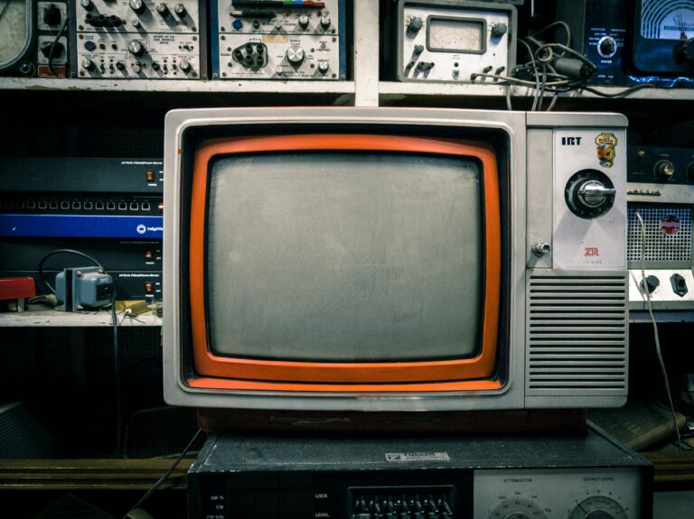 Vintage orange television set against a colorful background, representing how media like Love Island shapes desire and relationships