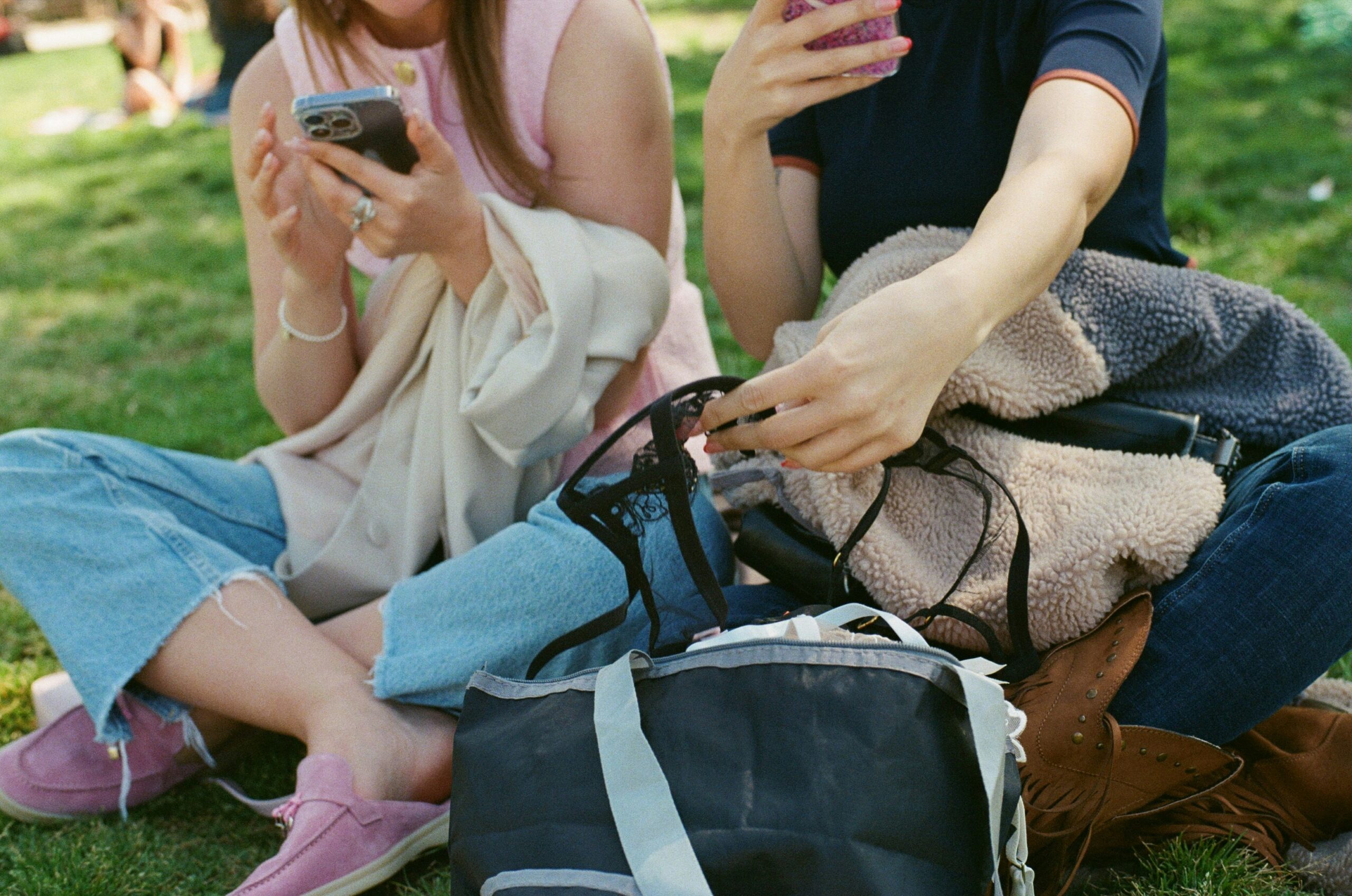 Group of young people sitting on grass looking at their phones, representing Gen Z Christians asking real questions about sex and purity