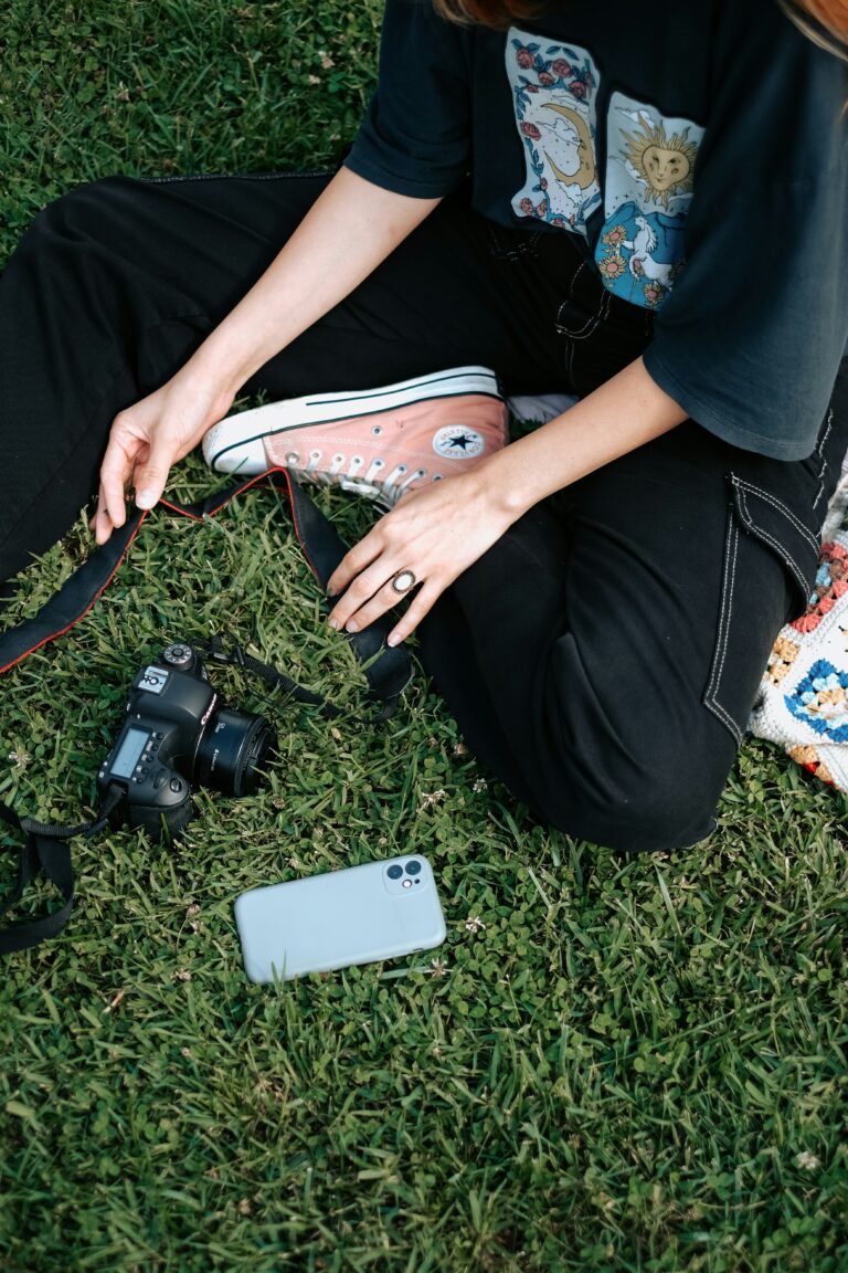 Hands resting on grass beside sneakers and a camera, representing everyday life and the subtle lies about sexual temptation