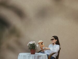 Two women sitting at an outdoor table having an honest conversation, representing vulnerability and trust when dealing with a partner's porn addiction