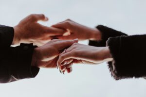 Multiple hands clasped together in a circle showing connection and community