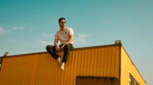 Man standing confidently on a yellow shipping container, representing what Christian men really look for in a future wife