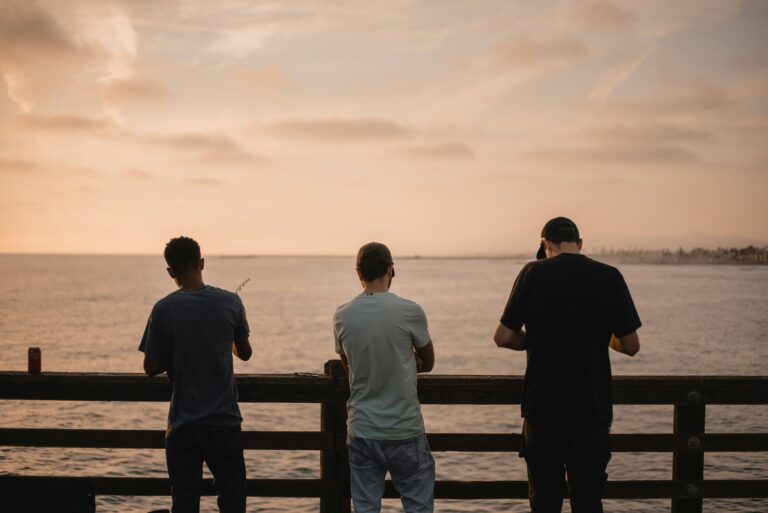 Friends gathered together at sunset on a beach pier, reflecting on the lessons Christian men wish they knew before getting married