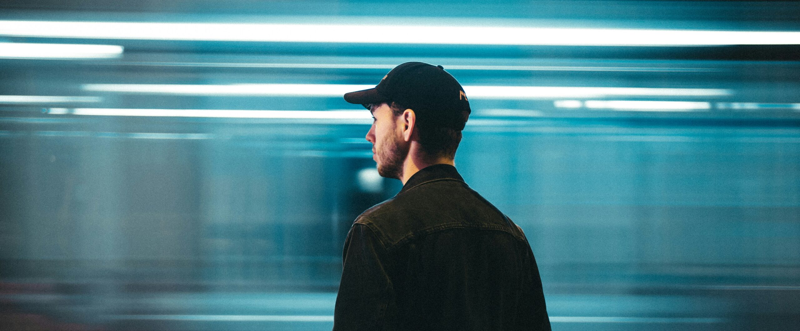 Man standing before blue neon lights in contemplation, reflecting on the moment Jesus spoke freedom over Ben Fitzgerald's life