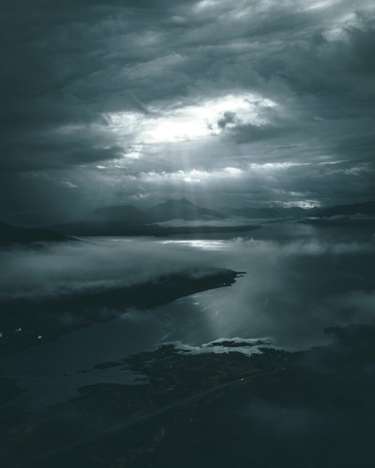 Misty sea with a distant island under a grey, cloudy sky