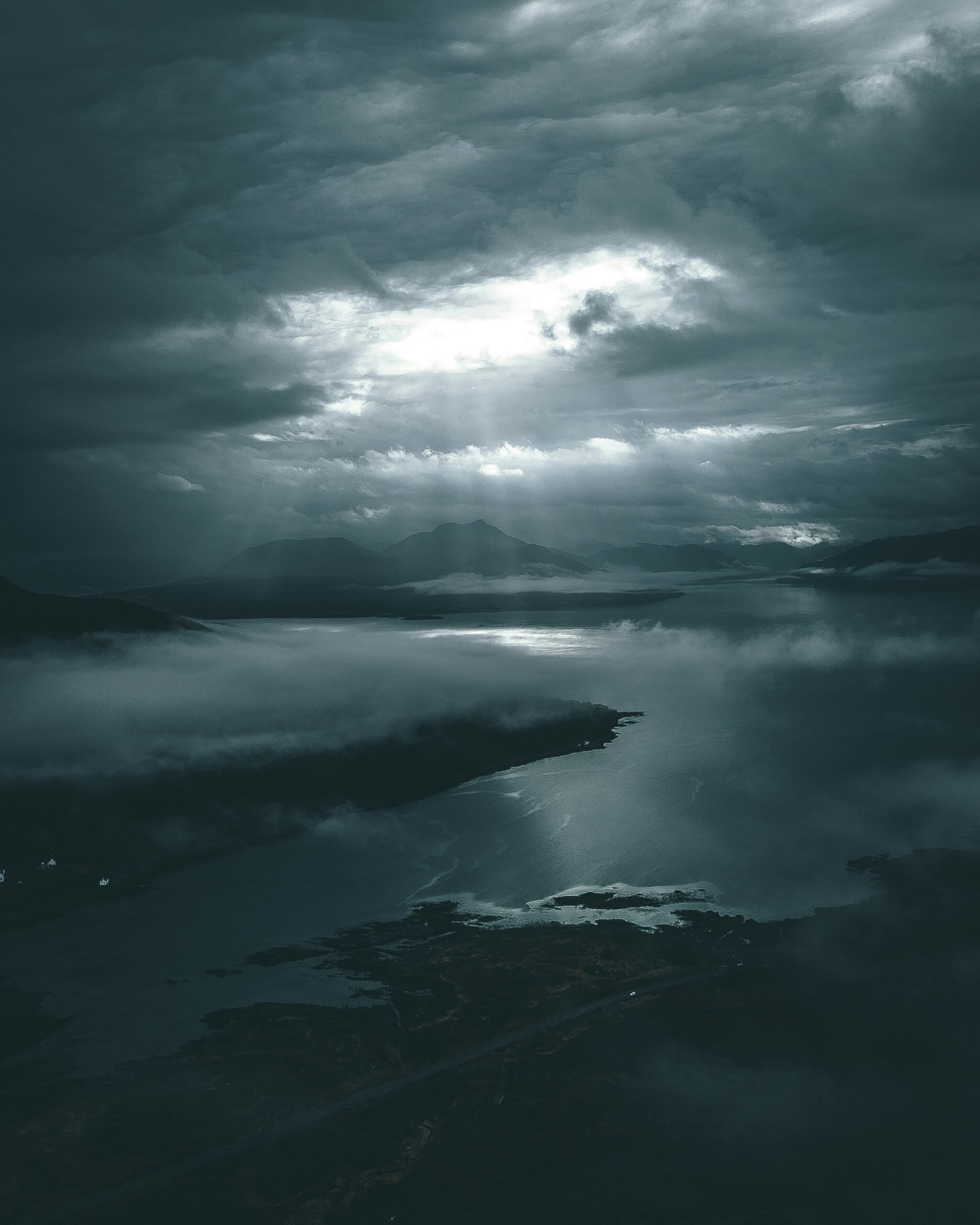 Misty sea with a distant island under a grey, cloudy sky