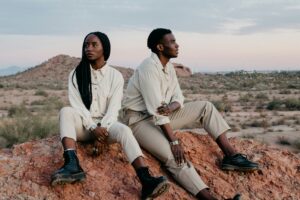 Couple sitting together on a desert outcrop at golden hour, talking about where their relationship is going