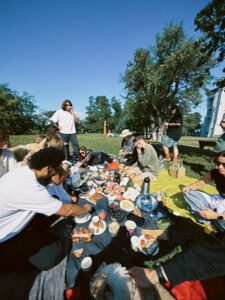 Let's Talk About It Podcast - Dating When Everyone Knows Everyone: a group of friends sharing a picnic spread on blankets under trees in a sunny park