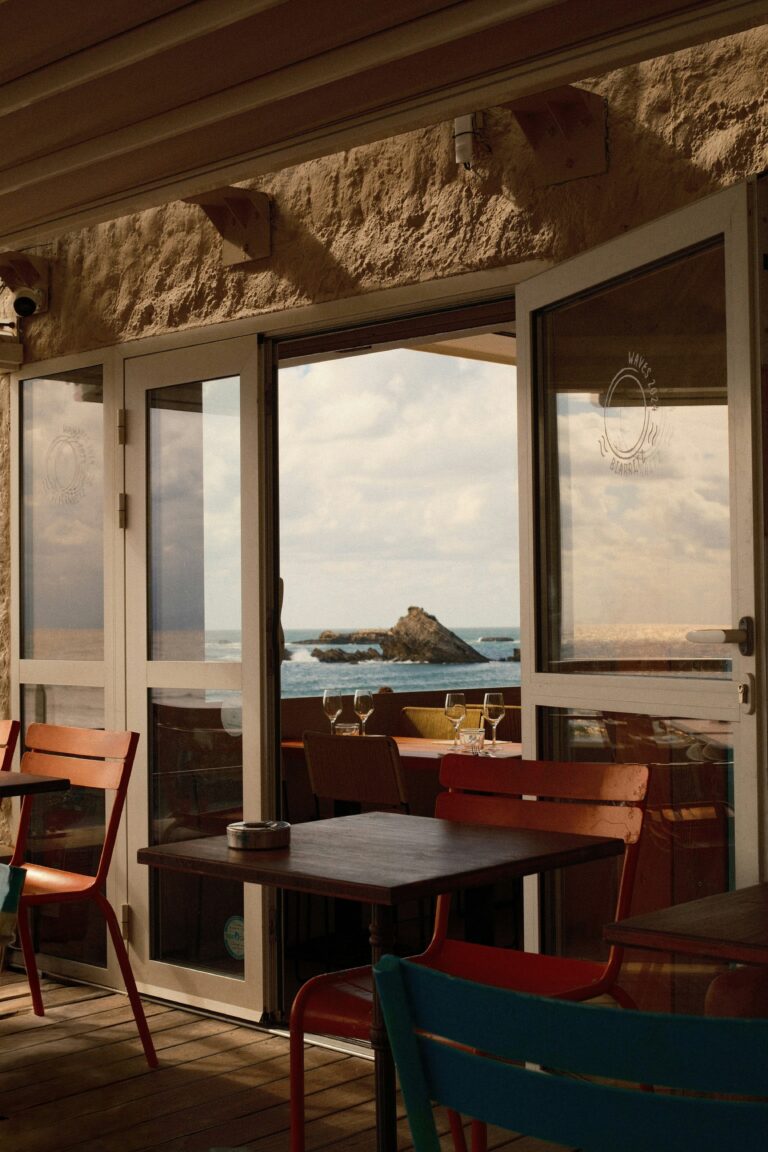 Cafe table set for two beside open doors looking out over the sea, a quiet place for the hard conversations of Christian dating