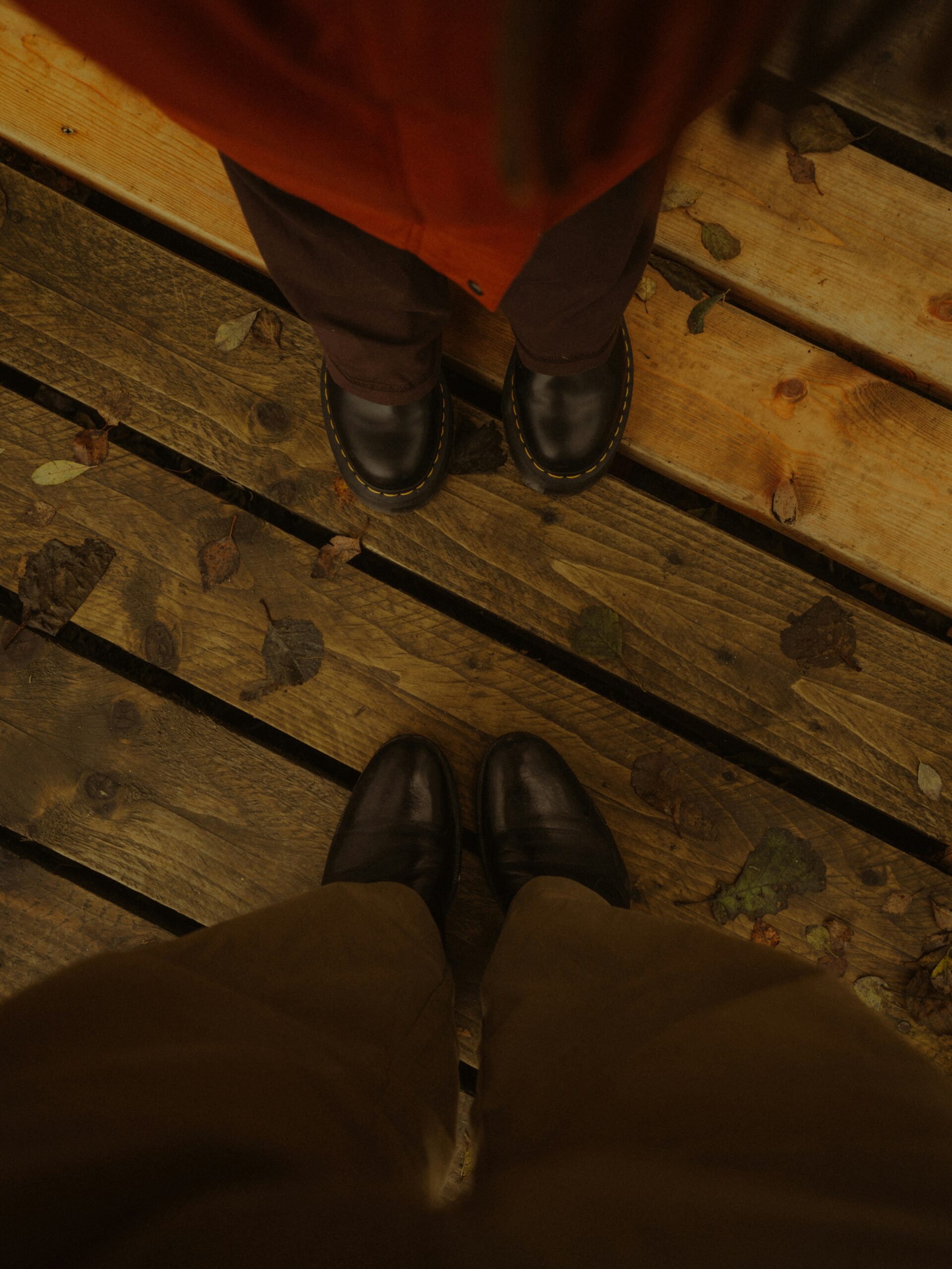 Two people facing each other on a wooden deck, seen from above.
